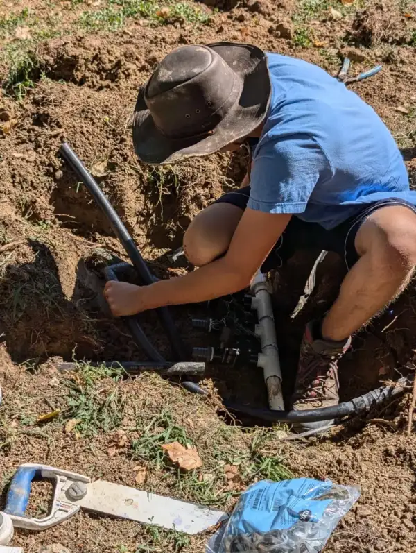 Home 2 - repair web 600 - Lotic Irrigation | Irrigation Repair & Lawn Maintenance | Fort Collins, CO | Experienced Professionals Lotic Irrigation technician repairing a broken sprinkler pipe in Fort Collins